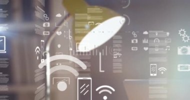 Dijital simgelerin ve veri işlemenin dijital kompozit videosu ofis masasındaki lambaya karşı. küresel finans ve iş kavramı