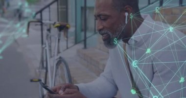 Akıllı telefon kullanarak Afrikalı Amerikalı kıdemli bir adama karşı dönen dijital simgeler küresi. küresel ağ ve iş konsepti