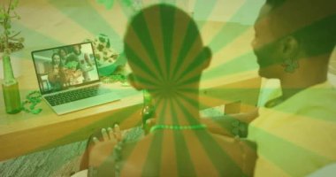 Yeşil çizgili bir animasyon ve dizüstü bilgisayardaki arkadaşlarıyla Aziz Patrick gününü kutlayan bir çift. İrlanda geleneği ve şenlik konsepti dijital olarak oluşturuldu.