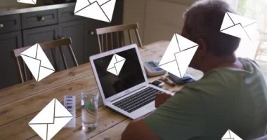 Arka planda dizüstü bilgisayar kullanan yaşlı adamın üzerindeki zarf simgelerinin canlandırması. dijital arayüz, bağlantı ve iletişim konsepti dijital olarak oluşturulmuş video.