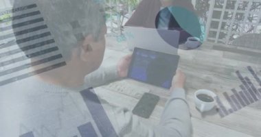 Dijital tablet kullanan Afrikalı Amerikalı bir adama karşı istatistiksel veri işleme. küresel finans ve iş teknolojisi kavramı