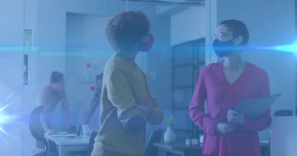 オフィスで女性の会話や顔のマスクを身に着けている上に輝く光の歩道のアニメーション グローバルCovid 19パンデミック 健康と医療の概念デジタルで生成されたビデオ — ストック動画