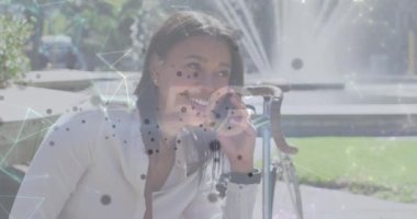 Şehirdeki akıllı telefon kullanan bir kadın üzerinde bağlantıları ve noktaları olan 5G metin animasyonu. dijital arayüz, bağlantı ve iletişim konsepti dijital olarak oluşturulmuş video.