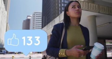 Şehirde akıllı telefon kullanan bir kadının üzerinde numaralar değişen başparmaklar ikonunun canlandırması. dijital arayüz, sosyal medya, bağlantı ve iletişim konsepti dijital olarak oluşturulmuş video.