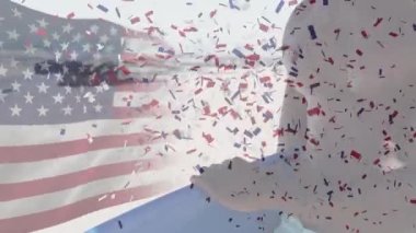 Amerikan bayrağının dalgalanması ve konfetilerin sahilin manzarasına hayran olan adamın üzerine düşmesi.