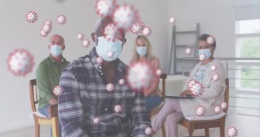 Evde oturan yüz maskesi takan bir grup insana karşı çoklu covid-19 hücreleri var. Karantina karantinasında tek başına evde kalmak