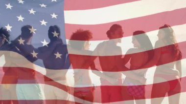 Sahilde kucaklaşan bir grup arkadaşın üzerinde Amerikan bayrağını sallayan animasyon. ABD vatanseverliği ve demokrasi kavramı dijital olarak oluşturulmuş video.