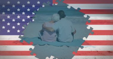 Amerikan bayrağı yapbozlarının animasyonu yaşlı çiftin plajda kucaklaştığını gösteriyor. ABD vatanseverliği ve demokrasi kavramı dijital olarak oluşturulmuş video.