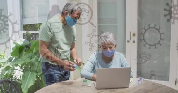 Animación Covid Iconos Sobre Pareja Ancianos Usando Portátil Con Máscaras — Vídeo de stock