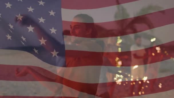 Animatie van de Amerikaanse vlag zwaaiend over een groep vrienden met sterretjes op het strand — Stockvideo