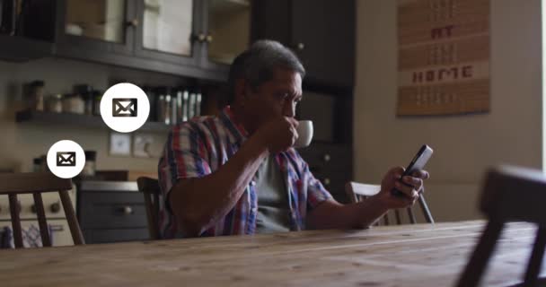 Multiple message icons floating against senior using smartphone at home — Stock Video