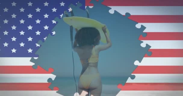 Animazione di puzzle bandiera americana rivelando donna che trasporta tavola da surf sulla testa sulla spiaggia — Video Stock