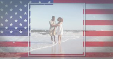 Sahilde dans eden kadın ve erkeğin üzerinde sallanan Amerikan bayrağının animasyonu. ABD vatanseverliği ve demokrasi kavramı dijital olarak oluşturulmuş video.