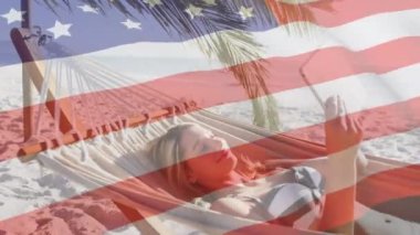 Amerikan bayrağının kumsalda akıllı telefon kullanarak hamakta sallanmasının animasyonu. ABD vatanseverliği ve demokrasi kavramı dijital olarak oluşturulmuş video.