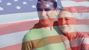 Sahilde birbirini seven yaşlı bir çiftin üzerinde Amerikan bayrağının dalgalandığı animasyon. ABD vatanseverliği ve demokrasi kavramı dijital olarak oluşturulmuş video.