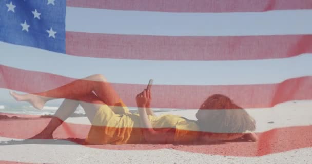 Animação Bandeira Americana Acenando Sobre Mulher Usando Tablet Deitado Praia — Vídeo de Stock