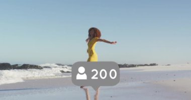 Animation of speech bubble with people icon and numbers over woman spinning on beach. digital interface, social media and global network concept digitally generated video.