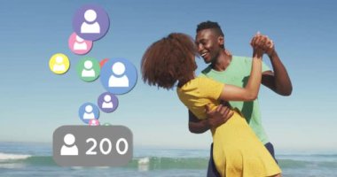 Profile icons with increasing numbers against african american couple dancing on the beach. social media networking and vacation concept