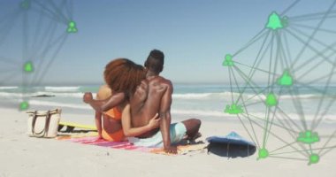 Sosyal medya dijital ikonlarıyla dönen ağların animasyonu plajda kucaklaşan çiftler üzerine. dijital arayüz, sosyal medya ve küresel ağ konsepti dijital olarak oluşturulmuş video.