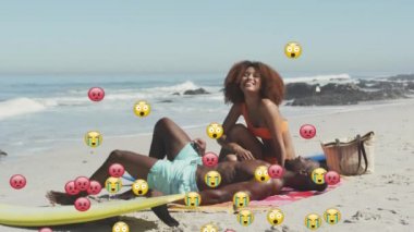 Animation of social media emojis over smiling couple on beach. digital interface, social media and global network concept digitally generated video.