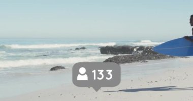 Animation of speech bubble with people icon and numbers over couple running with surfboards on beach. digital interface, social media and global network concept digitally generated video.
