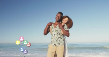 Animation of social media people icons over smiling couple in love on beach. digital interface, social media and global network concept digitally generated video.