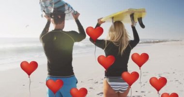 Animation of red heart love balloons digital icons over couple carrying surfboards on beach. digital interface, social media and global networking concept digitally generated video.