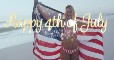 Happy 4th of july text against caucasian woman wrapping american around her on the beach. american independence patriotic holiday concept