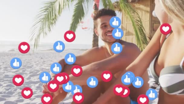 Heart Icons Floating Caucasian Couple Talking While Sitting Beach Social — Stock video