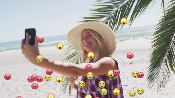 Mehrere Gesichts Emojis Schweben Gegen Eine Kaukasische Frau Die Strand — Stockvideo