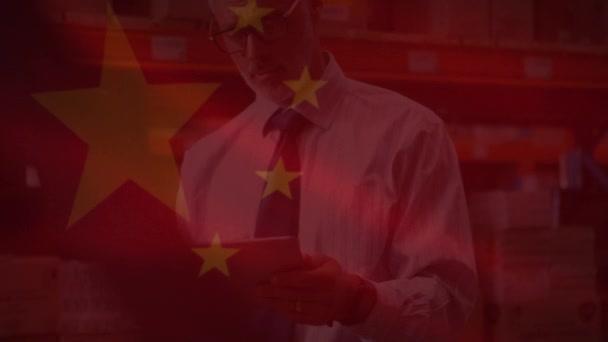 倉庫でタブレットを使用して人に手を振る中国の国旗のアニメーション 世界中の金融とビジネスの概念をデジタルで — ストック動画