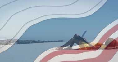 Sahilde dizüstü bilgisayar kullanan Afro-Amerikan bir kadına karşı mavi çizgili birden fazla yıldız. Amerika 'nın bağımsızlığı vatansever tatil konsepti