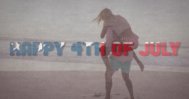 独立日的文字反对高加索男人给他的妻子在海滩搭便车 美国独立爱国假日的概念 — 图库视频影像
