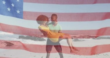 Amerikan bayrağı, Afrika kökenli Amerikalı bir adamın karısını plajdan almasına karşı sallanıyor. Amerika 'nın bağımsızlığı vatansever tatil konsepti