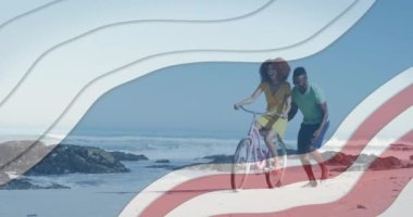 Mavi çizgili birden fazla yıldız plajda bisiklet süren Afrikalı Amerikalı çifte karşı. Amerika 'nın bağımsızlığı vatansever tatil konsepti