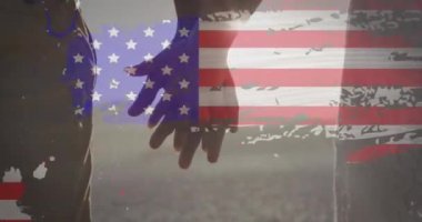 Sahilde el ele tutuşan çiftlerin orta kesimine karşı arıza etkisi olan Amerikan bayrağı. Amerika 'nın bağımsızlığı vatansever tatil konsepti