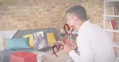 Bilgisayarda video görüşmesi yaparken kalp şeklinde bir levha taşıyan beyaz bir adamın kalp simgeleri. Sevgililer Günü 'nün uzak kutlaması online ve flört konsepti