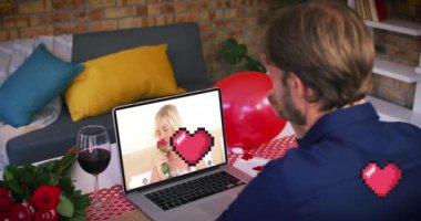 Pikselleştirilmiş kırmızı kalp simgeleri beyaz adamın üzerinde yüzerken dizüstü bilgisayarda bir video görüşmesi yapıyor. Sevgililer Günü 'nün uzak kutlaması online ve flört konsepti