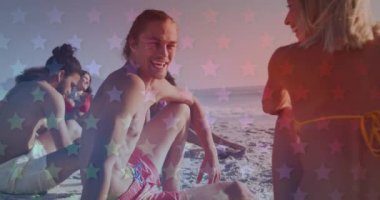 Sahilde oturan bir grup arkadaşa karşı yanıp sönen yıldızlar. Amerika 'nın bağımsızlığı vatansever tatil konsepti