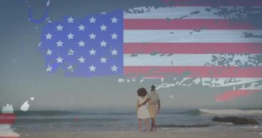 Sahilde yürüyen bir çiftin dikiz aynasından yansıyan Amerikan bayrağı. Amerika 'nın bağımsızlığı vatansever tatil konsepti