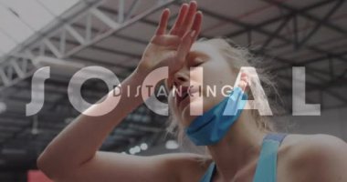 Spor salonunda maskesi indirilmiş yorgun, beyaz bir kadına karşı sosyal mesafeli mesaj. Coronavirus covid-19 pandemik ve fitness konsepti