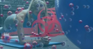 Biyolojik tehlike sembolü ve kovid 19 hücreleri yüz maskesi takan kadınlara karşı spor salonunda tahta egzersizi yapıyorlar. Coronavirus covid-19 pandemik ve fitness konsepti