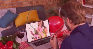 Neon 'un kalbi, laptopta bir video görüşmesi yaparken beyaz bir adamın yüzük göstermesi karşısında yanıp sönüyor. Sevgililer Günü 'nün uzak kutlaması online ve flört konsepti