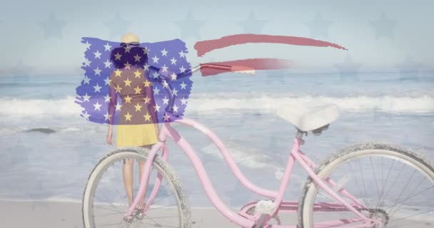 Американський Прапор Махає Задній Погляд Афріканську Жінку Велосипедом Пляжі Патріотичне — стокове відео