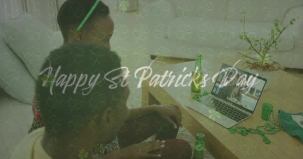 快乐的St Patricks白天的文字和三叶草离开反对夫妇在笔记本电脑上的视频通话在家里 圣帕特里克节庆祝活动的概念 — 图库视频影像