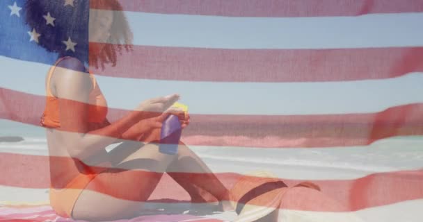 Amerikaanse Vlag Zwaaiend Tegen Afro Amerikaanse Vrouw Die Zonnebrandcrème Aanbrengt — Stockvideo