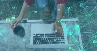 Evde dizüstü bilgisayar kullanan bir kadının dijital simgelerle olan bağlantılarının animasyonu. küresel sosyal medya ve çevrimiçi bağlantı konsepti dijital olarak oluşturulmuş video.