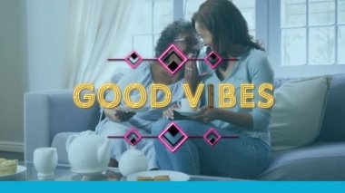 Evde çay içip gülümseyen iki kadın için iyi titreşimlerin animasyonu. küresel sosyal medya ve çevrimiçi bağlantı konsepti dijital olarak oluşturulmuş video.