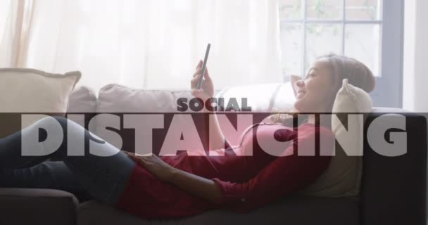 Animation Social Distancing Text Woman Using Smartphone Home Global Coronavirus — Stock Video