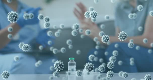 在家中桌上的Covid 19疫苗瓶上漂浮着多个Covid 19细胞 Coronavirus Covid 19流行病概念 — 图库视频影像